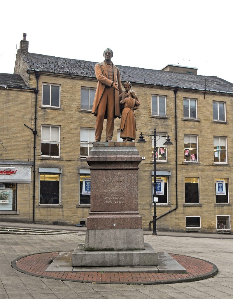 Statue on a plinth of Richard Oastler with two children.